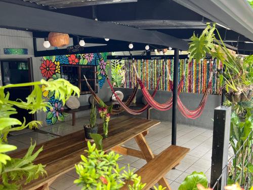 a patio with a bench and hammocks at Pura Vida Hostel in Montezuma