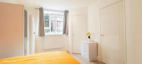 een slaapkamer met een bed en een raam bij Daisy Garden in Marylebone in Londen