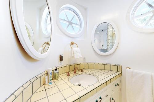 uma casa de banho com um lavatório e 2 espelhos em Peace on the Pacific em Ventura