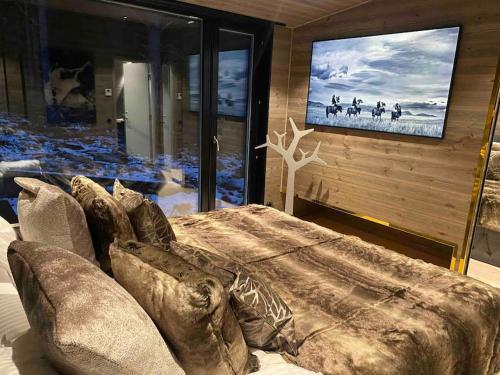 a living room with a large bed and a tv at Vackert fjällhus med underbar utsikt in Järvsö