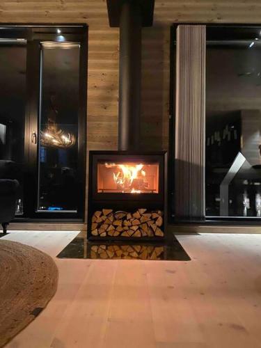 a living room with a fireplace with logs in it at Vackert fjällhus med underbar utsikt in Järvsö