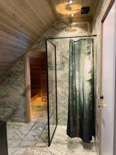 a shower in a room with a stone wall at Vackert fjällhus med underbar utsikt in Järvsö