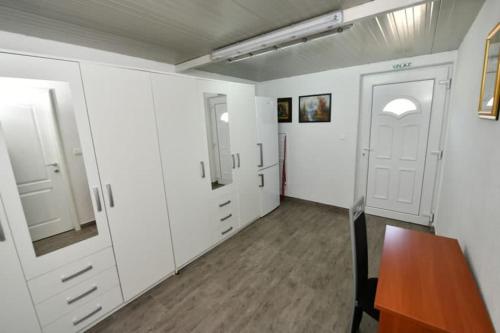 an empty room with white cabinets and a wooden table at Kovacic Villa with pool, tennis cart and free parking in Hrvace