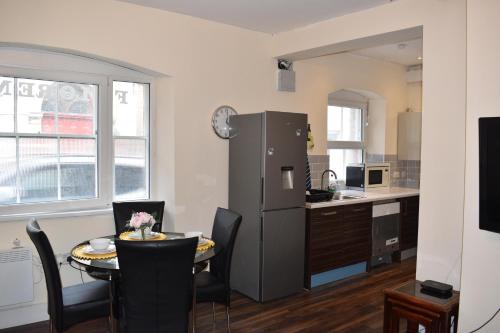 a kitchen and dining room with a table and a refrigerator at Large heritage-House close Snowdonia & Llandudno in Denbigh