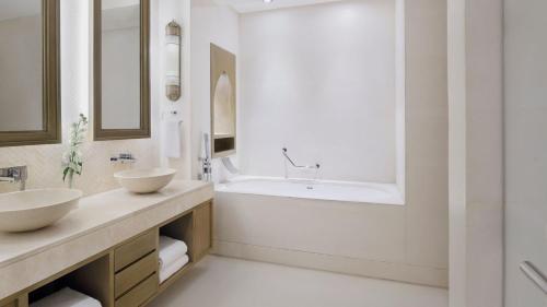 a bathroom with two sinks and a tub at InterContinental Durrat Al Riyadh Resort & Spa by IHG in Riyadh