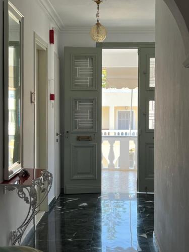 a hallway with a green door and a table at Kamelia Hotel in Spetses
