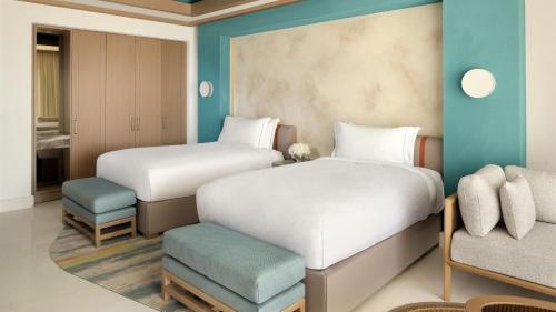 two beds and a chair in a room at InterContinental Durrat Al Riyadh Resort & Spa by IHG in Riyadh
