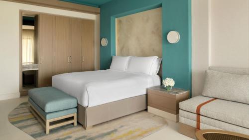 a bedroom with a white bed and a blue wall at InterContinental Durrat Al Riyadh Resort & Spa by IHG in Riyadh