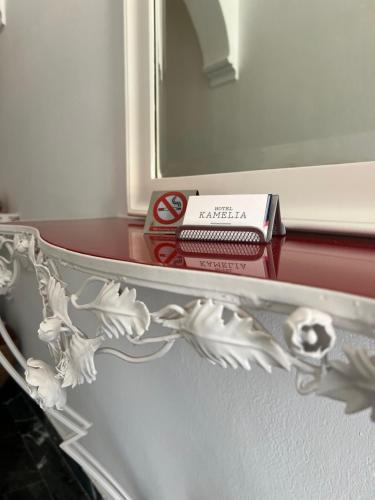 a mirror and a book on a shelf in a room at Kamelia Hotel in Spetses