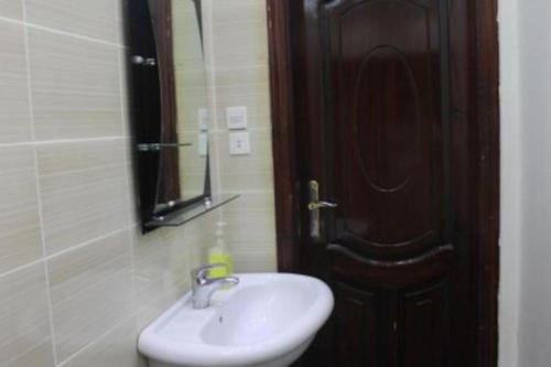 a bathroom with a sink and a mirror and a door at شقة خاصة للعائلات فقط in Medina