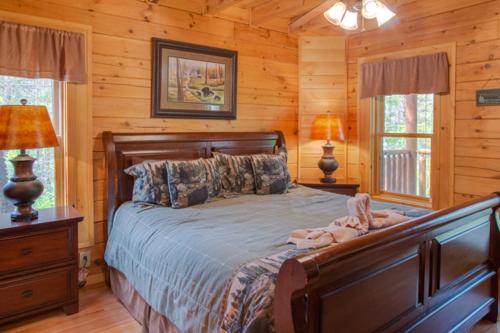 - une chambre avec un lit dans une cabane en rondins dans l'établissement Peyton's Hideaway, 3 Bedrooms, Sleeps 10, Yard, Hot Tub, Pet Friendly, WiFi, à Gatlinburg