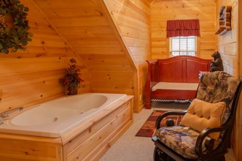 - une salle de bains avec une grande baignoire dans une cabane en rondins dans l'établissement Peyton's Hideaway, 3 Bedrooms, Sleeps 10, Yard, Hot Tub, Pet Friendly, WiFi, à Gatlinburg