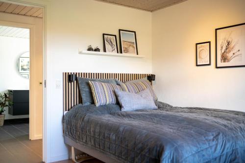 a bedroom with a bed with blue blankets and pillows at Bjerrebo idyl - Romalt Bakker in Randers