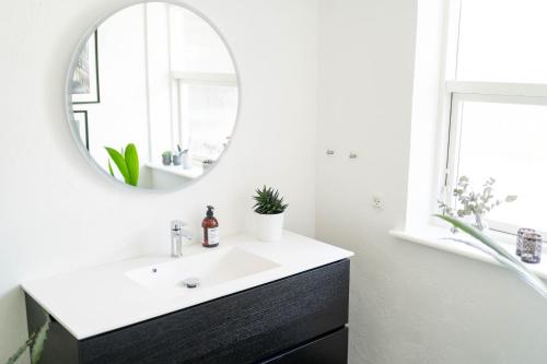 a bathroom with a sink and a mirror at Bjerrebo idyl - Romalt Bakker in Randers