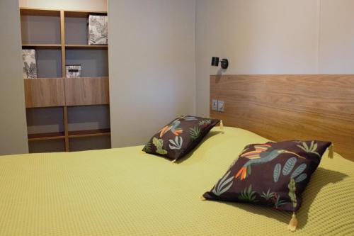 um quarto com uma cama com duas almofadas em Mobil Home neuf Hyères em Hyères