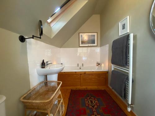 a bathroom with a sink and a bath tub at Crofts Mill in Ballater