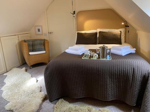a bedroom with a large bed with a tray on it at Crofts Mill in Ballater