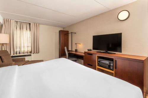 a hotel room with a bed and a flat screen tv at Comfort Inn in Kenora