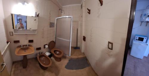 a bathroom with a sink and a toilet and a mirror at Panoramico in Santa Teresita