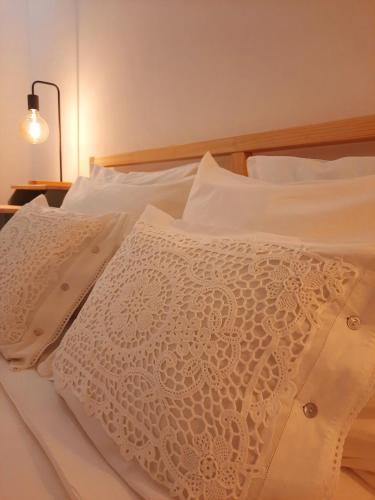 ein Bett mit weißer Bettwäsche und Kissen darauf in der Unterkunft Casa A Júlia In Faro's Heart in Faro