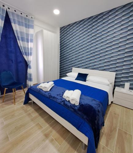 a bedroom with a large bed with two towels at Domus de loco sano in Castellammare di Stabia