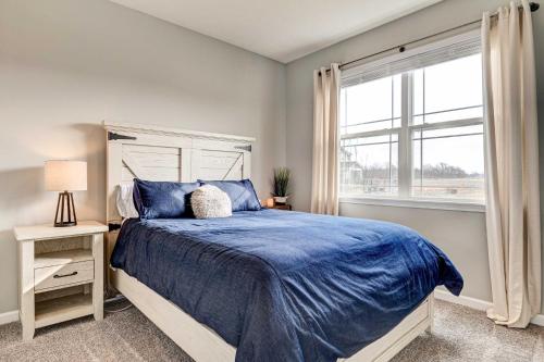 um quarto com uma cama com um edredão azul e uma janela em Vacation Rental Near Geist Reservoir 7 Mi Away! em Fishers