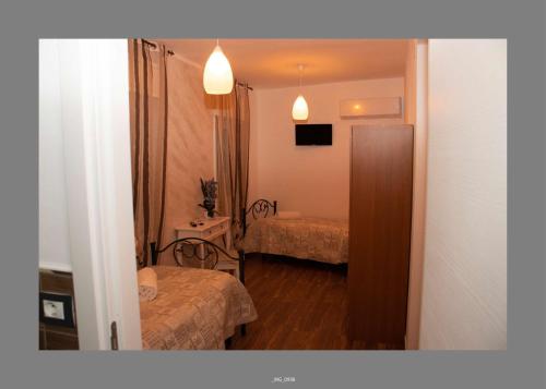 a small hotel room with two beds and a mirror at B&B Pastello in Agrigento