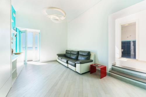 a living room with a black couch and a window at Casa Raiffone in Procida