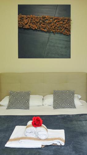 a bed with two towels and a red rose on it at Lake View 30 in Sulzano