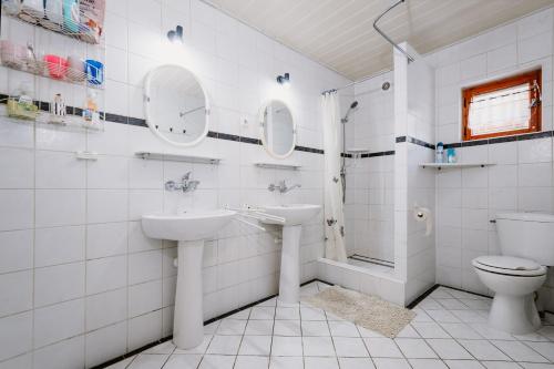 a white bathroom with a sink and a toilet at Chata Kokava Línia in Kokava na Rimavica