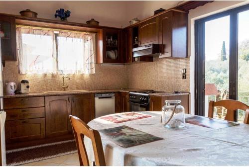 cocina con mesa, mesa y ventana en Ancient Olympia - Entire family house 