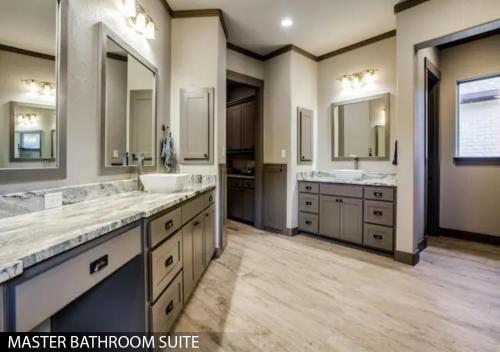 a master bathroom with two sinks and two mirrors at Hilltop Ranch House - Holiday & Family Destination in Valley View