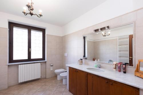 a bathroom with a sink and a toilet and a mirror at Villa Anna in Moncalieri