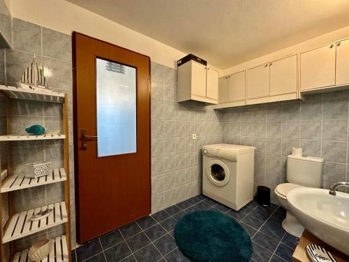 a bathroom with a toilet and a sink and a door at Apartments Relax in Piran