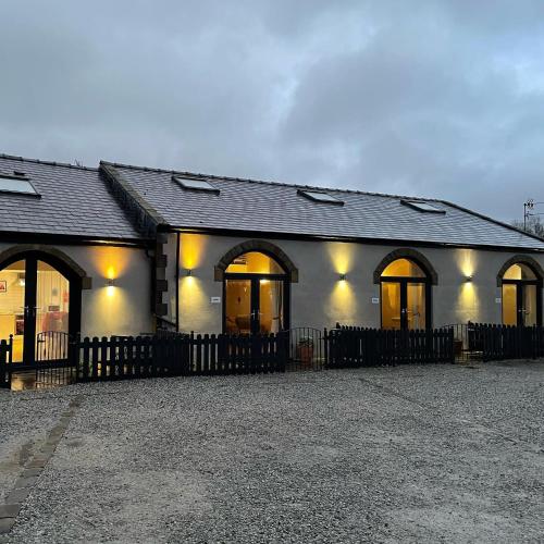 a building with a fence in front of it at Rossendale Holiday Cottages & Spa in Rossendale