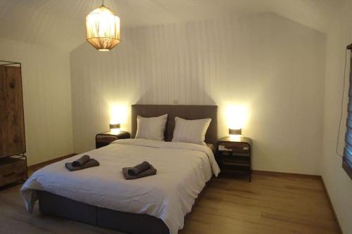 a bedroom with a bed with two slippers on it at L'escale tout confort in Charleroi