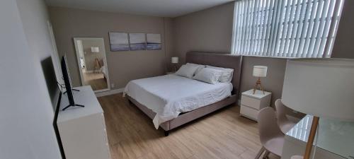 Dormitorio pequeño con cama y TV en NEW LUXURY APARTMENT 2Br 2Ba DIRECT BEACH ACCESS, en Hollywood