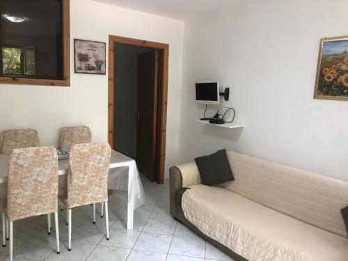 ein Wohnzimmer mit einem Sofa, einem Tisch und Stühlen in der Unterkunft Case vacanze Vignola in Peschici