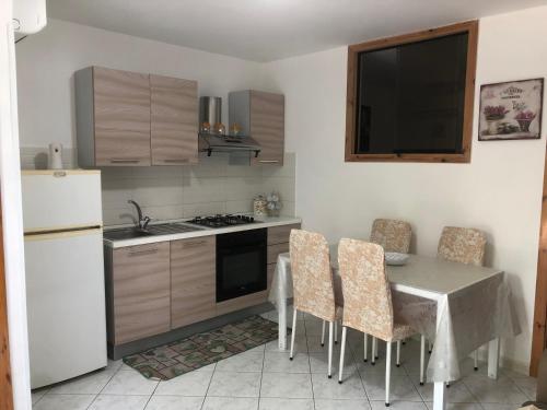 eine Küche mit einem Tisch mit Stühlen und einem Waschbecken in der Unterkunft Case vacanze Vignola in Peschici