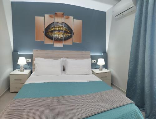 um quarto com uma cama com uma parede azul em MAXIM APARTMENT em Heraclião