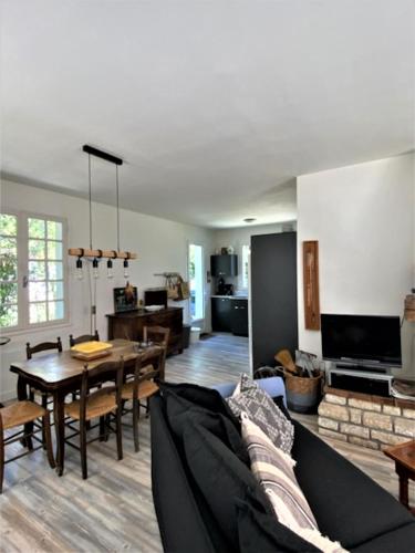 un salon avec un canapé et une table dans l'établissement La Haute Foret proche mer, à Grand-Village-Plage