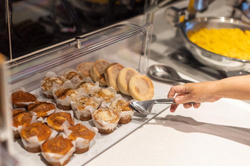 a person holding a spoon in front of a tray of food at SpringHill Suites by Marriott Tucson at The Bridges in Tucson