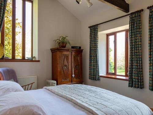 ein Schlafzimmer mit einem Bett und zwei Fenstern in der Unterkunft The Dairy in Kingsbridge