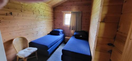 a room with two beds in a wooden cabin at Familie bungalow Sundsvall in Gramsbergen