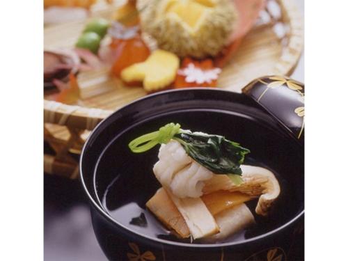 eine Schüssel mit Sushi und einem Teller Essen in der Unterkunft kamogawa Kan - Vacation STAY 17163v in Kyoto