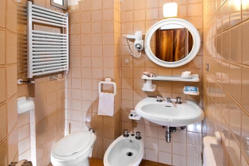 a bathroom with a sink and a toilet and a mirror at Hotel Le Querce in Senigallia