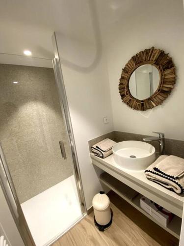 a bathroom with a shower and a sink and a mirror at La Cabane de la Plage in Quiberon