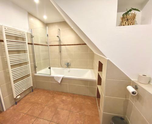 a bathroom with a bath tub and a sink at Ferienwohnungen Kapitänskajüte & Ausguck in Maasholm