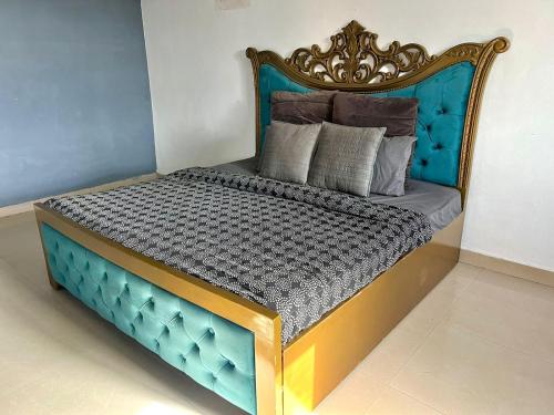 a bed with a blue frame and pillows on it at jacuzzi & spacious open terrace with room & bonfire in Gurgaon