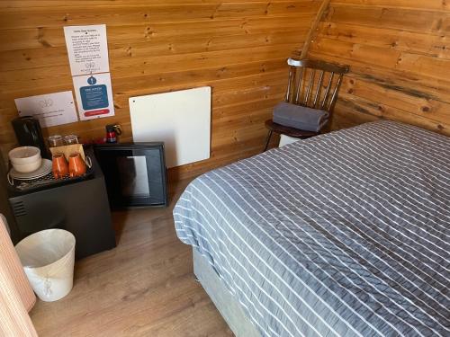 a bedroom with a bed and a wooden wall at Rossendale Holiday Cottages & Spa in Rossendale